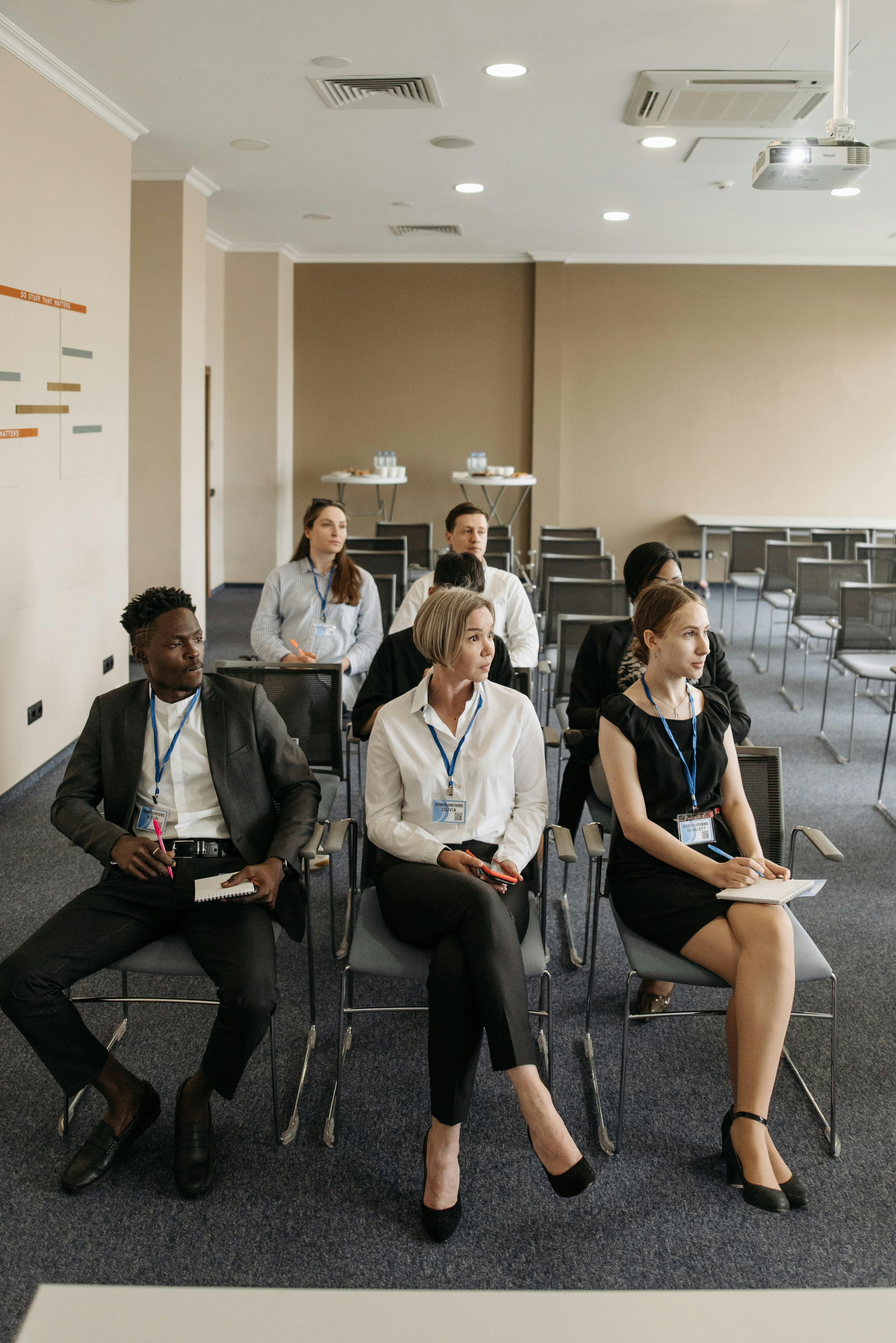 Group of professionals attentively sitting in a modern conference room setting.